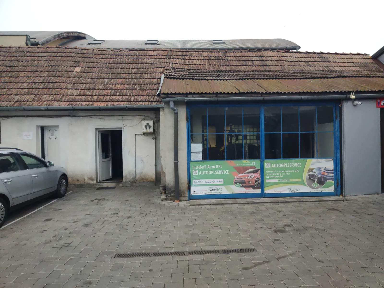 Service-ul AutoGpl din Florești: clădire cu vitrină albastră și afișe GPL
